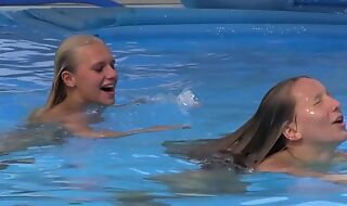 Two beautiful girls swimming and licking by the conjoin